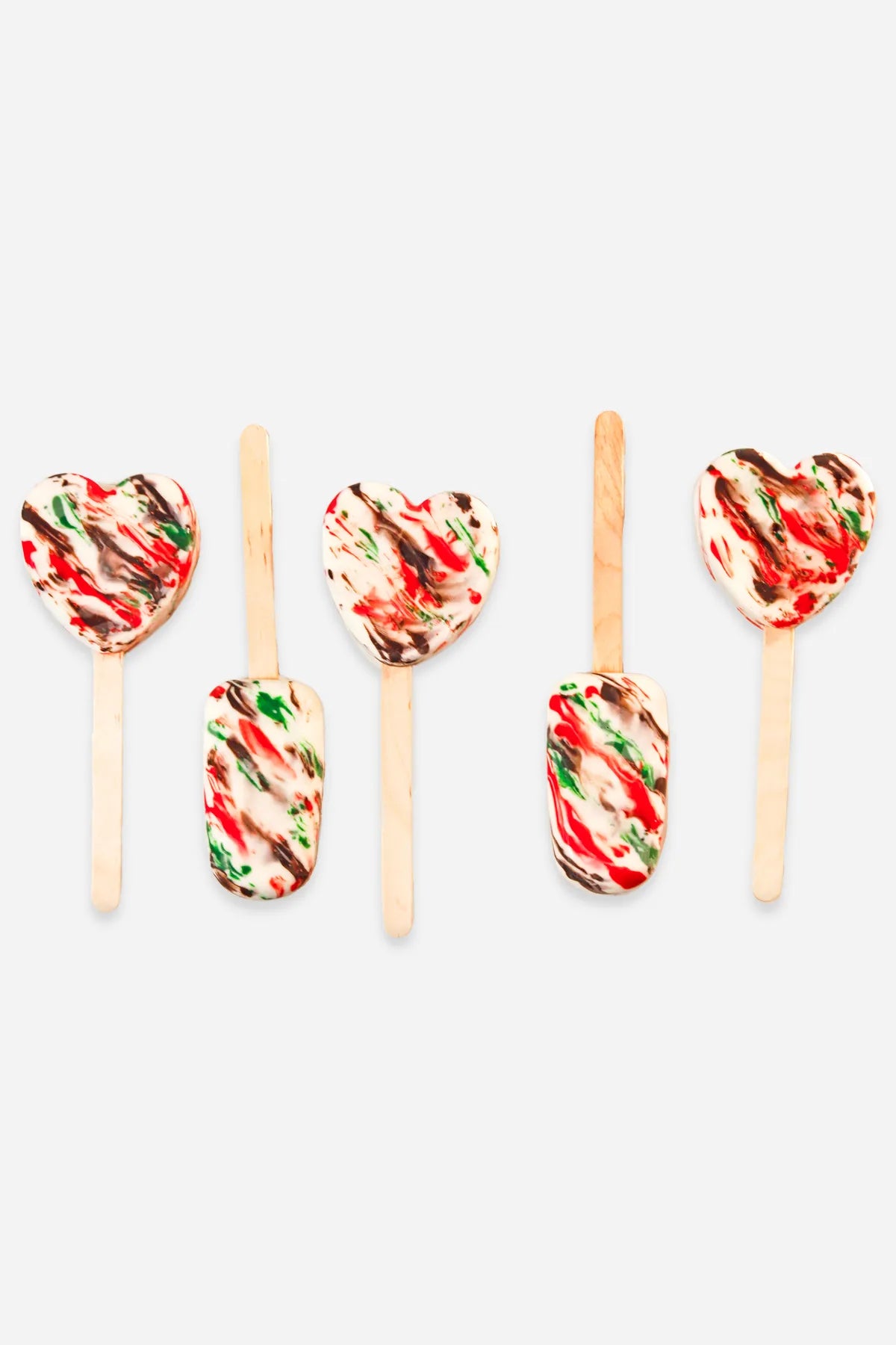 A set of four cakesicles decorated with a heart pattern in the colors of the UAE flag, coated in chocolate.