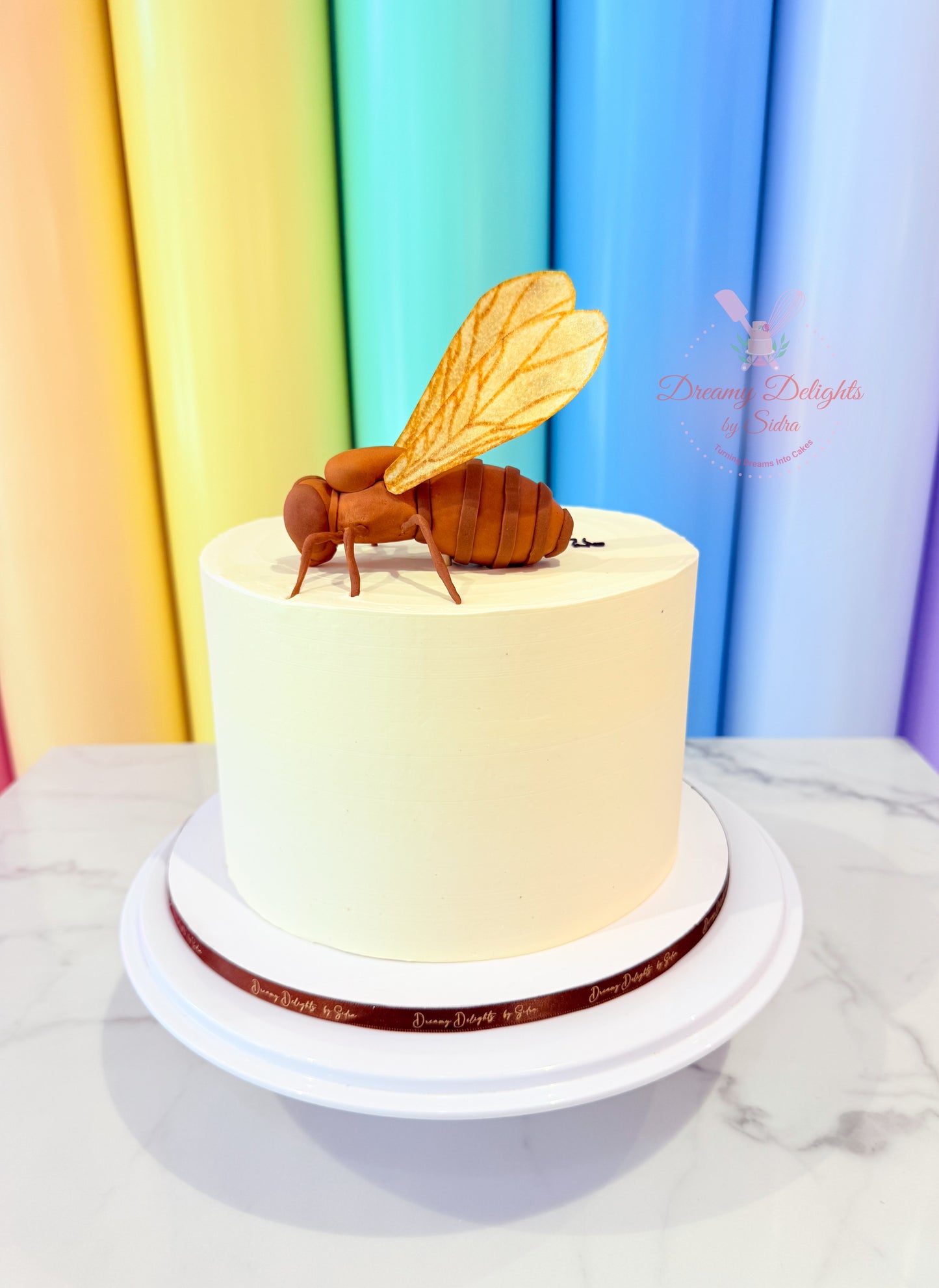 Cake with a bee decoration against a colorful curtain background