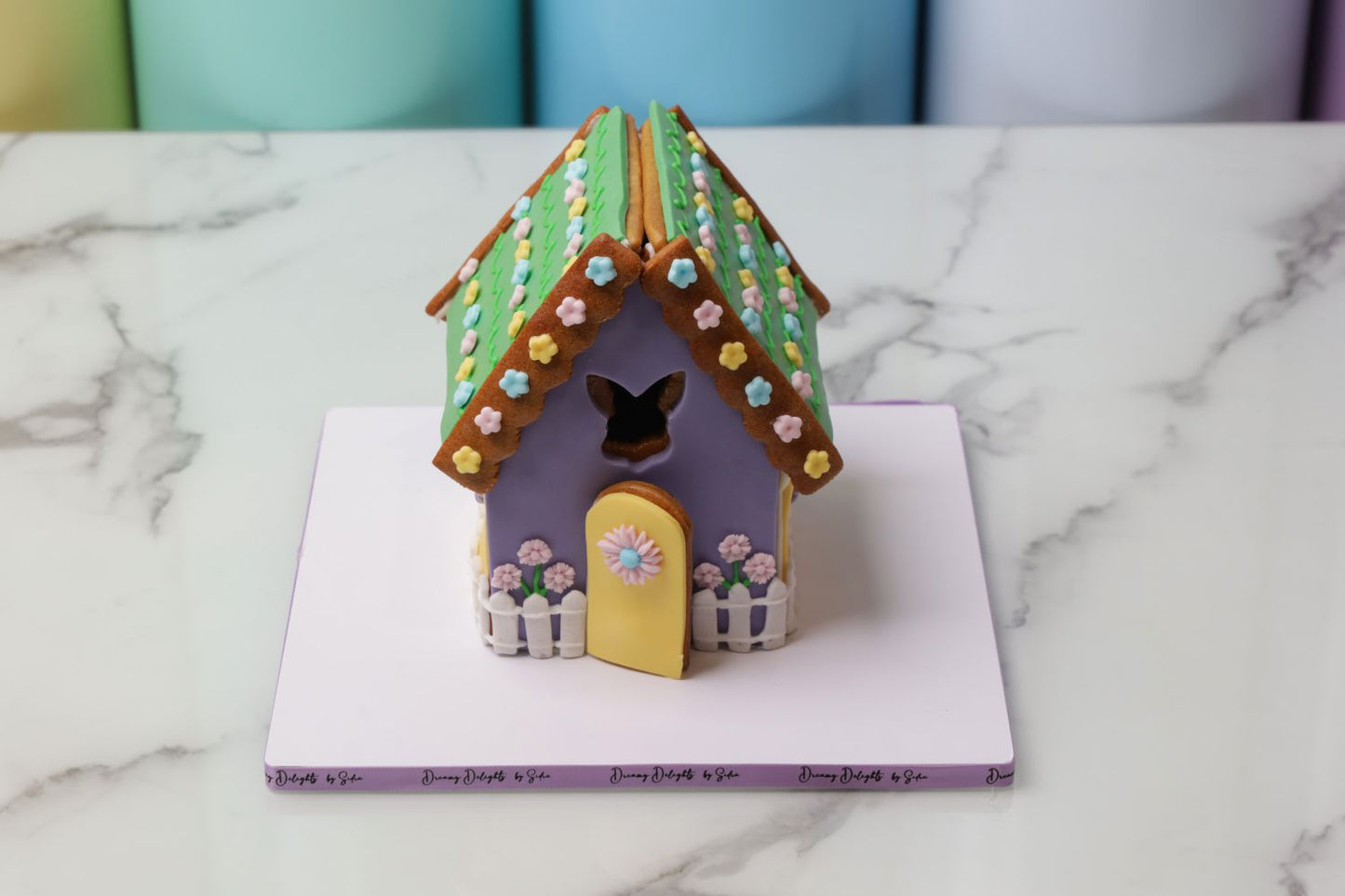 Easter gingerbread house cake Dubai with pastel icing and decorative flowers