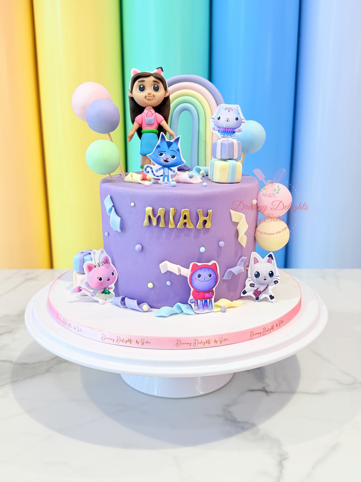 Gaby’s Dollhouse themed kids birthday cake for girls with pastel rainbow and cartoon character decorations in Dubai
