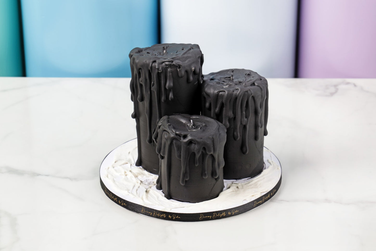 Black cake with dripping effect on a white stand against a colorful background