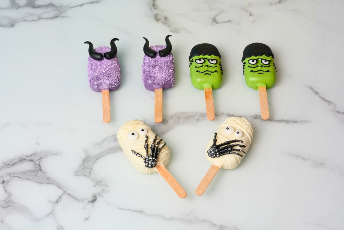 Six Halloween cakesickles decorated as witches, Frankenstein faces, and mummies by Dreamy Delights by Sidra in Dubai.