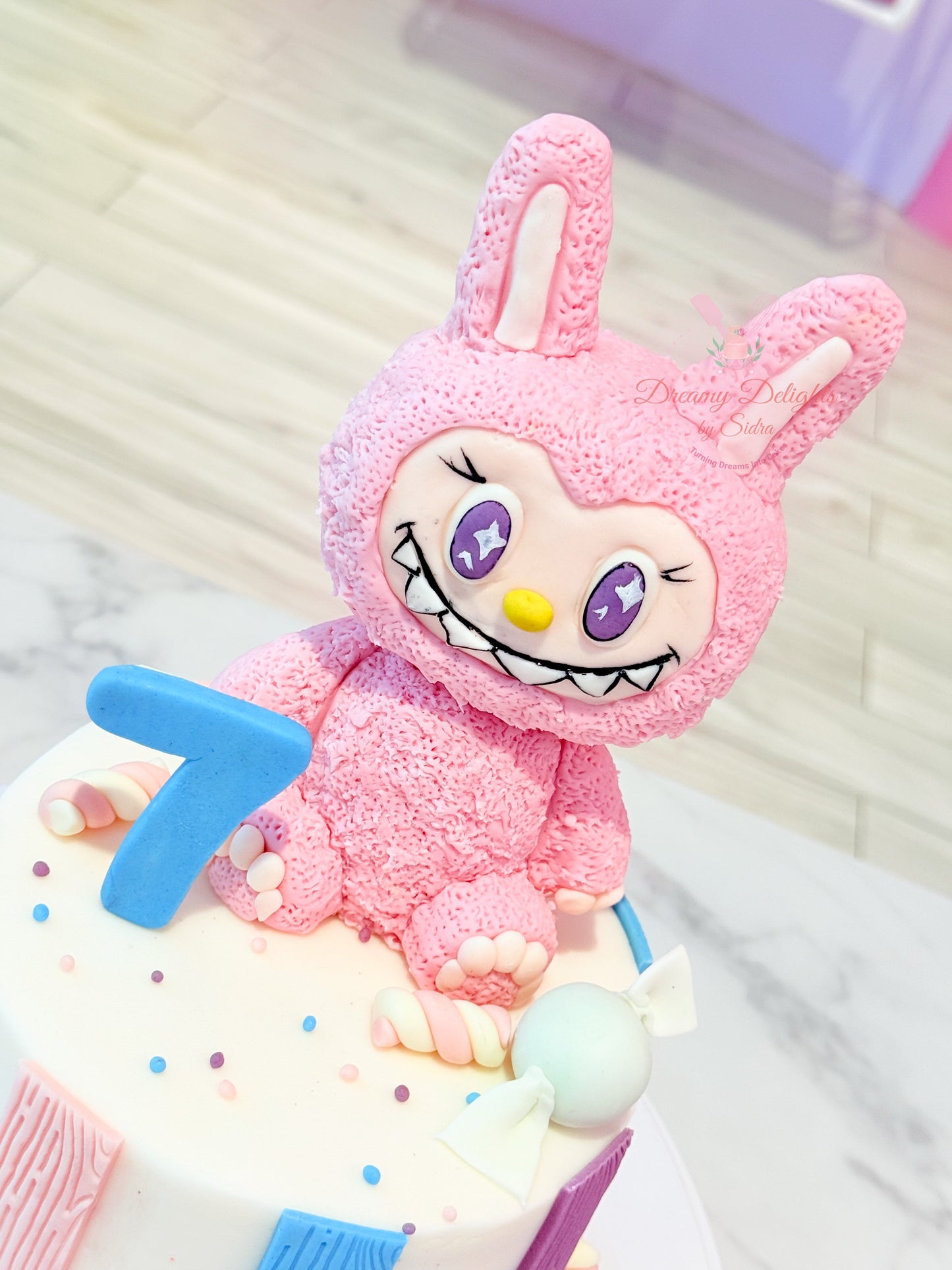 Pink bunny plush toy with a blue number 7 on a white background