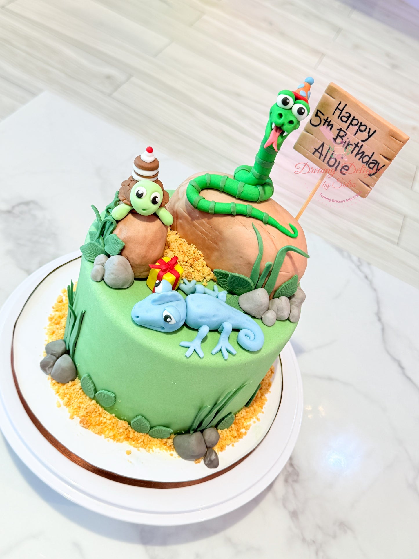 Birthday cake with animal-themed decorations on a white marble surface