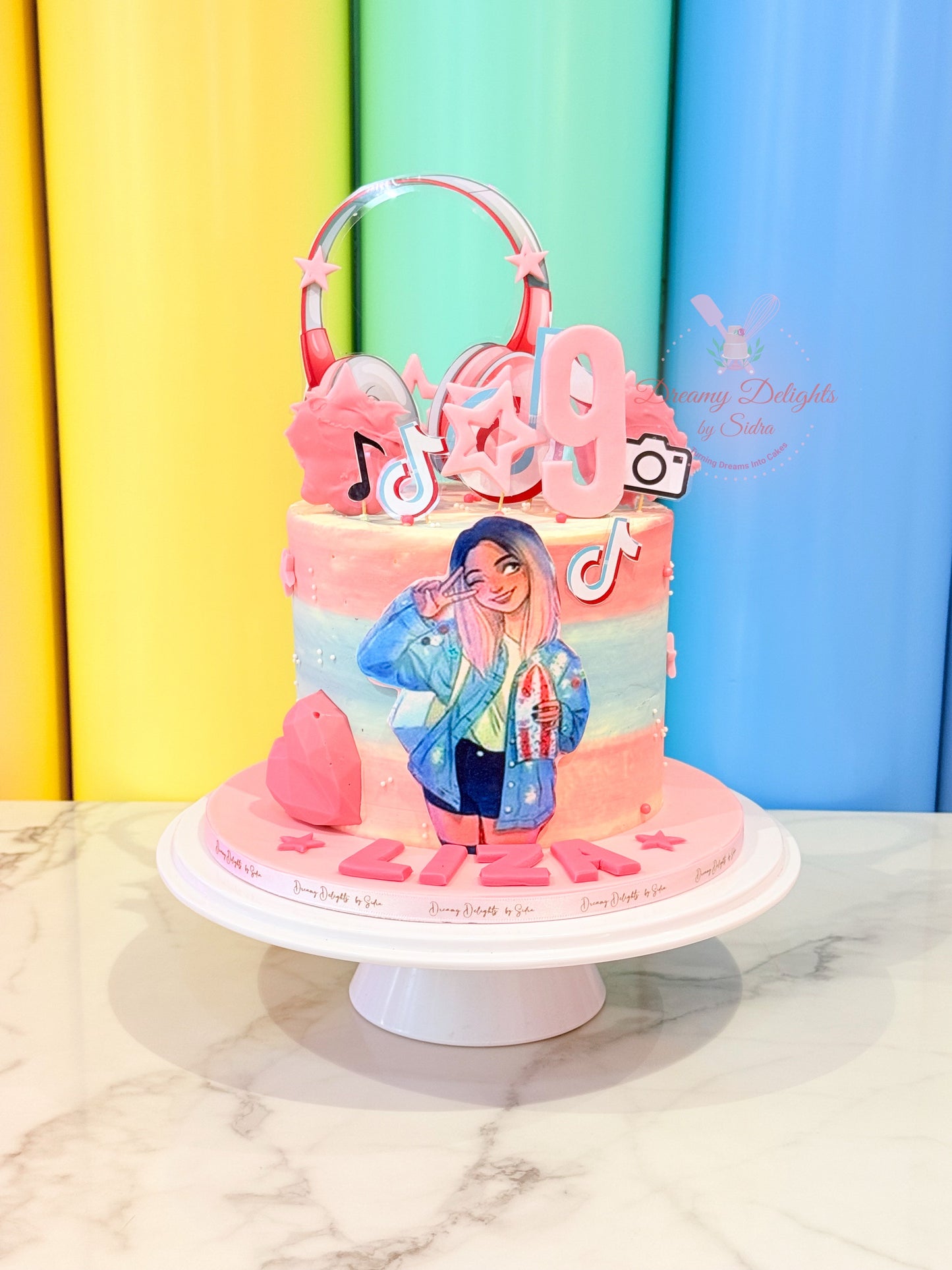 Colorful cake with cartoon character and music-themed decorations on a white marble surface.