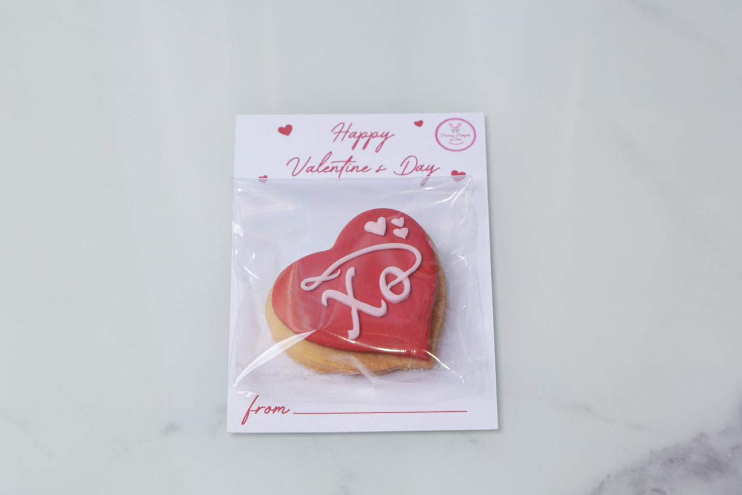 Valentine’s Day heart cookie attached to a greeting card with XO design by Dreamy Delight by Sidra