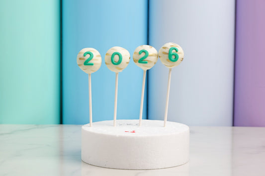 2026 New Year cakepops with white chocolate and gold accents by Dreamy Delight by Sidra