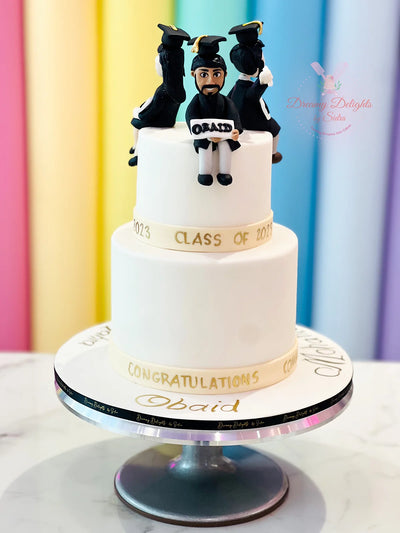 Custom graduation cake Dubai — elegant two-tier design with graduation cap topper by Dreamy Delights by Sidra