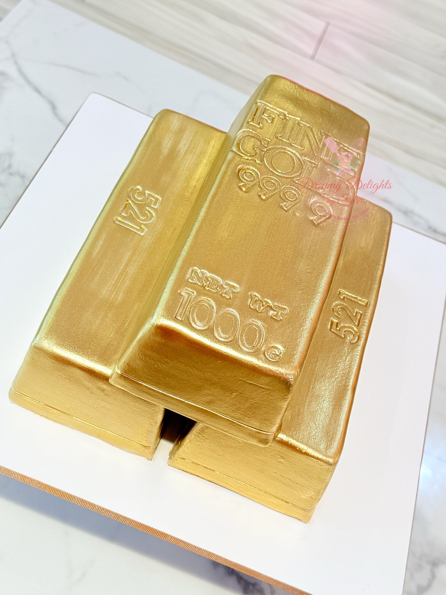 Two gold bars with '999' purity mark on a white surface