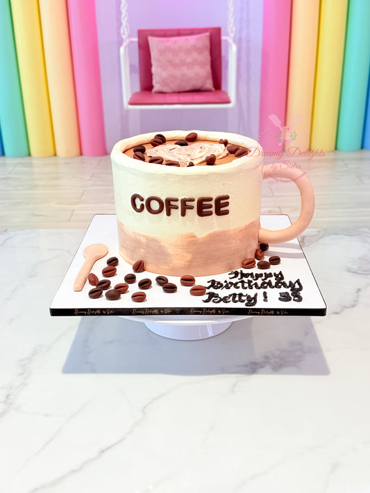 Coffee-themed birthday cake with 'COFFEE' text on a white marble surface.