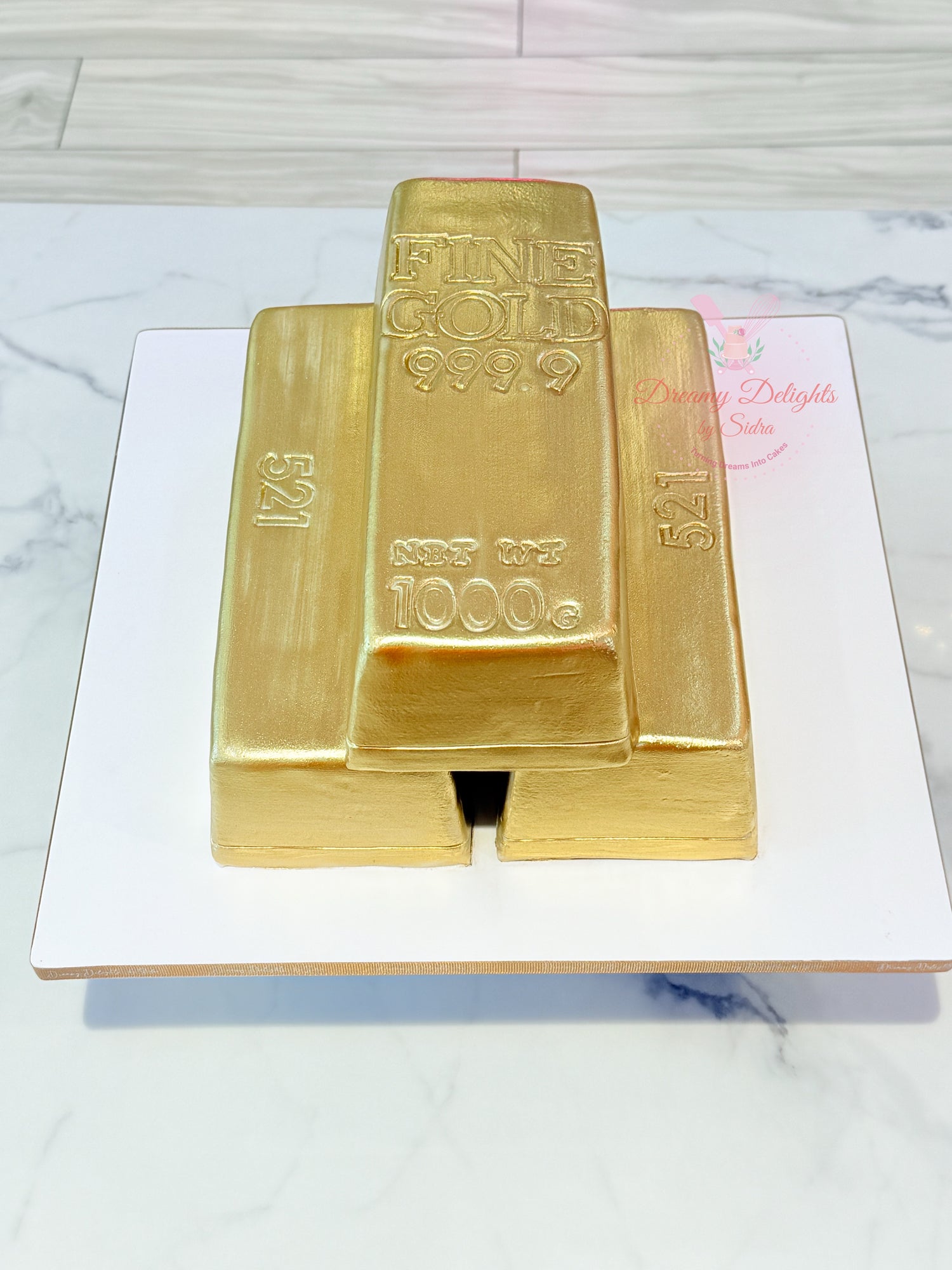 Gold bar cake on a white marble surface