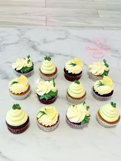 Assorted cupcakes with white and green frosting on a marble surface.