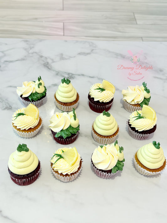 Assorted cupcakes with white and green frosting on a marble surface.