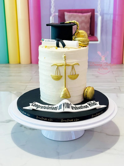 Law graduation cake Dubai — custom cake with legal scales and judge's robe topper by Dreamy Delights by Sidra