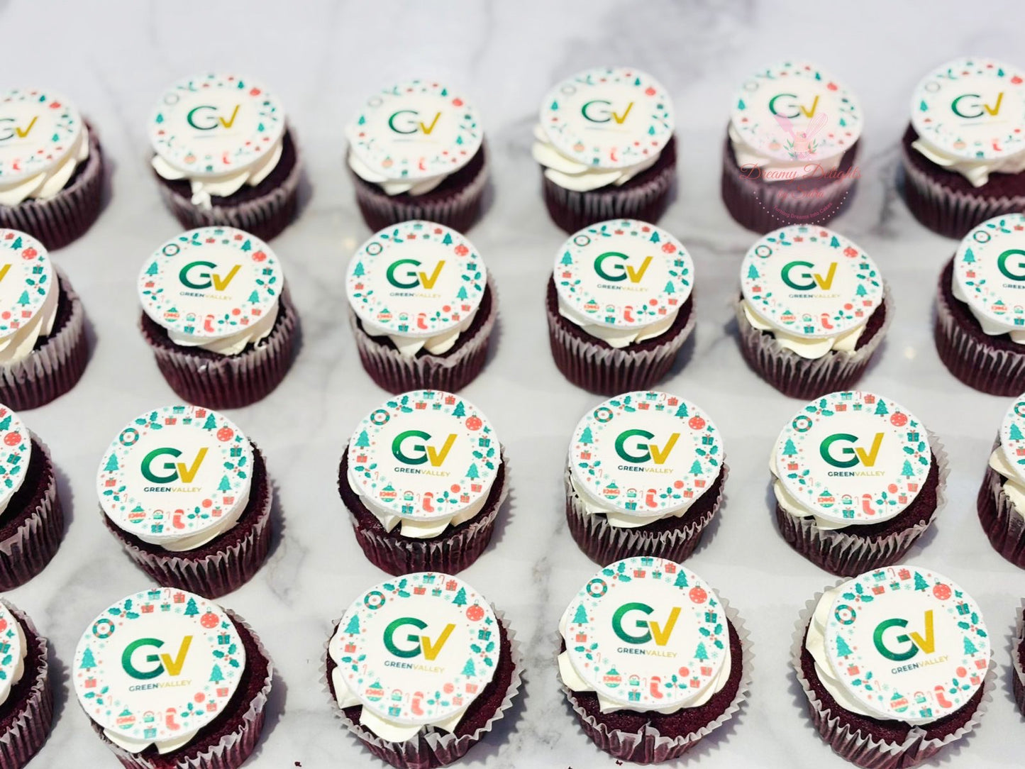 Row of corporate cupcakes with 'GV' logo on a white surface