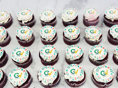 Row of corporate cupcakes with 'GV' logo on a white surface