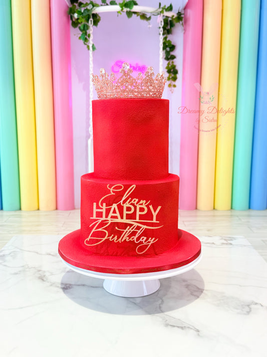 Red birthday cake with 'Happy Birthday' text against a colorful striped background