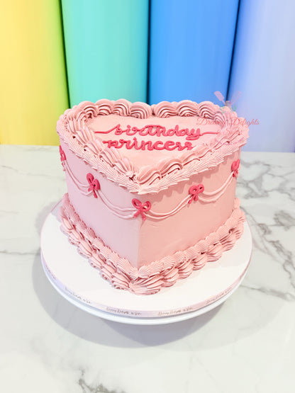 Pink birthday cake with 'birthday princess' text on a marble surface with colorful background