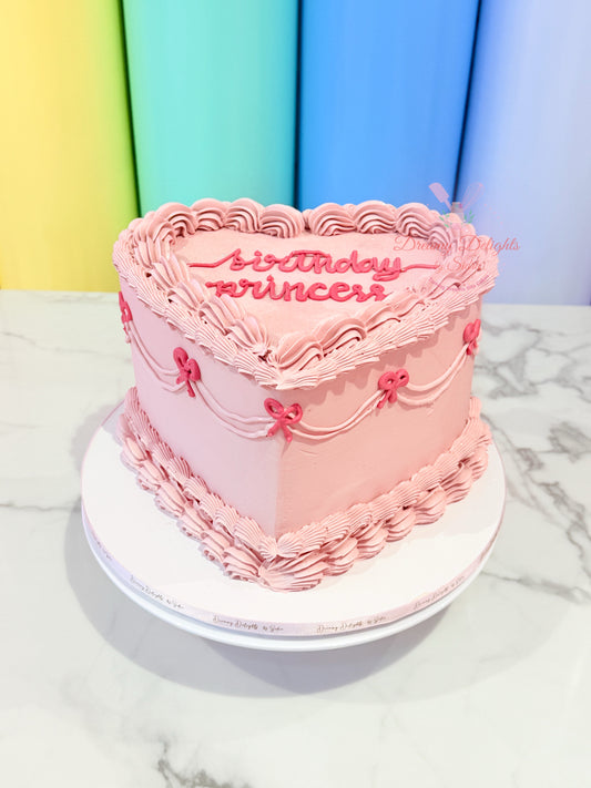 Pink birthday cake with 'birthday princess' text on a marble surface with colorful background