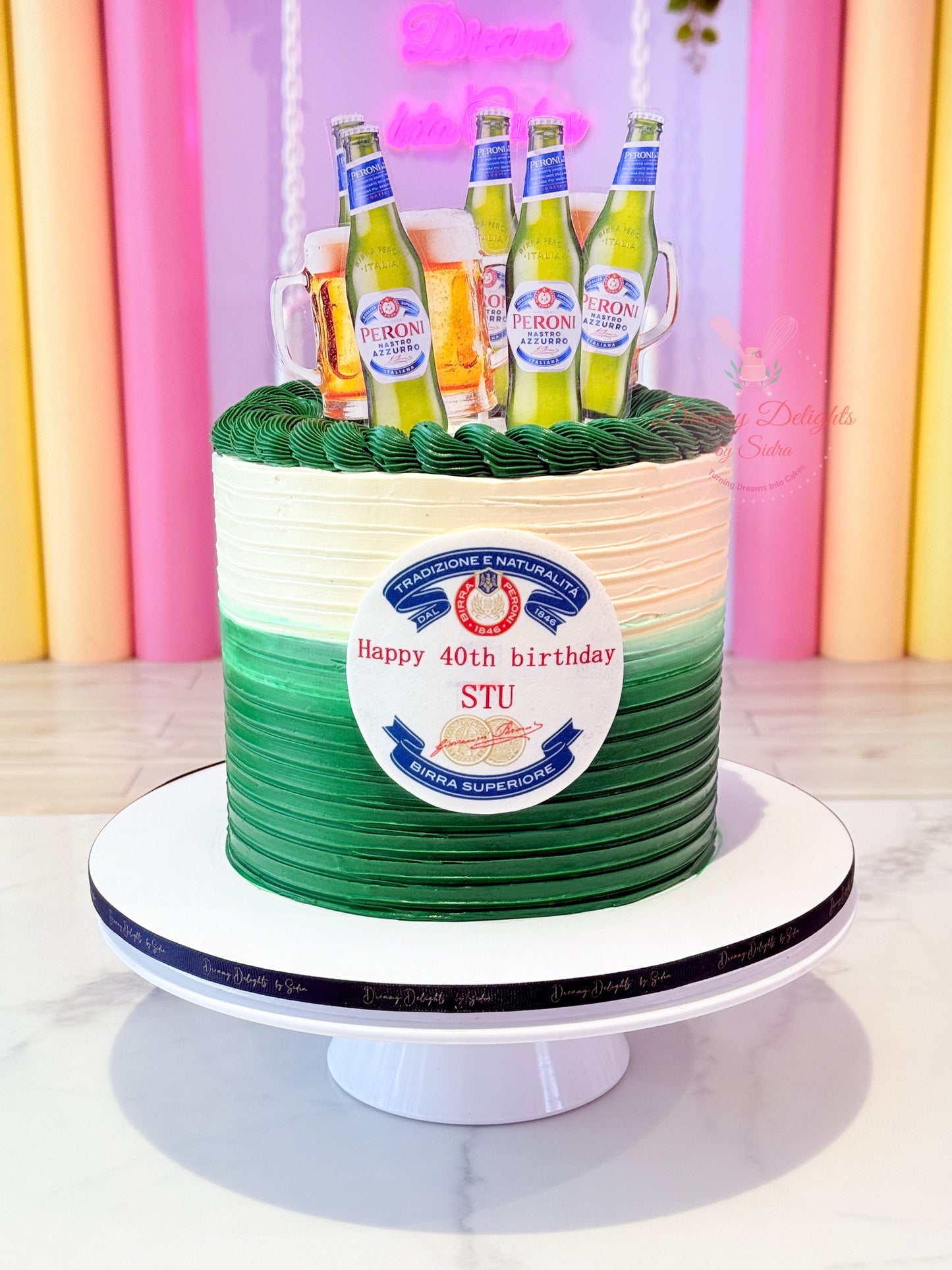 Birthday cake with green and white striped design and beer bottles on top, against a colorful background.