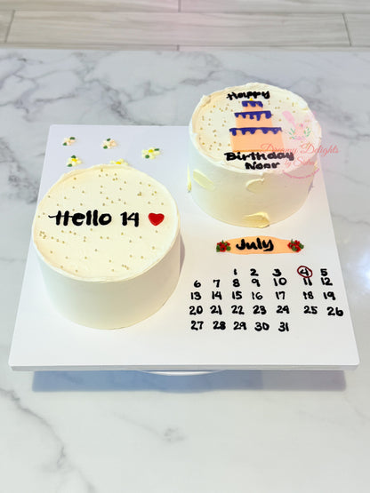 Two small cakes with text and a calendar on a marble surface
