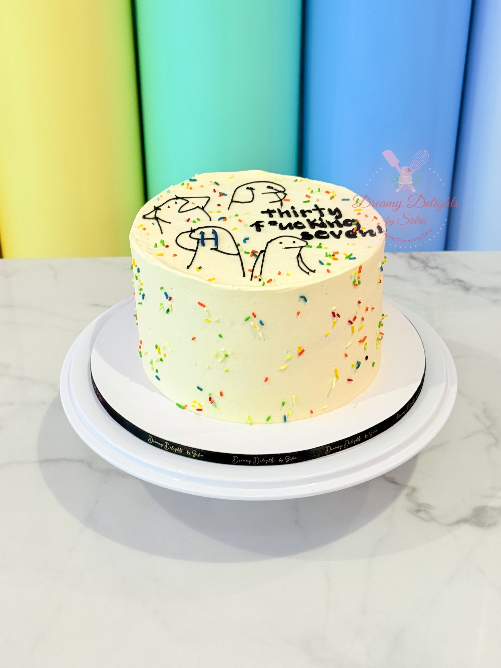Birthday cake with colorful sprinkles and text on a white plate against a colorful background