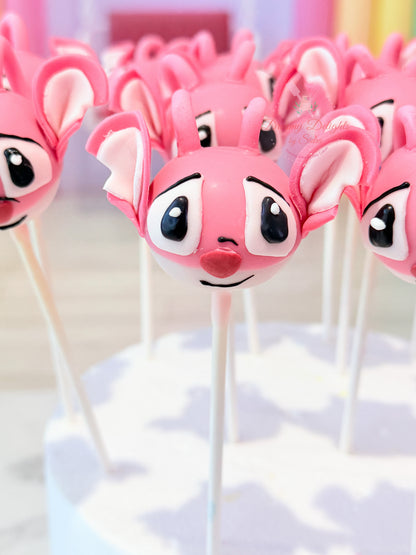 Pink character cake pops on sticks with a blurred background