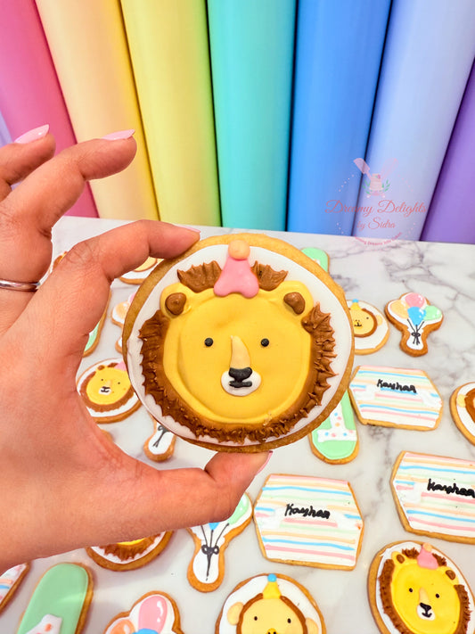 Hand holding a lion-shaped cookie with colorful background