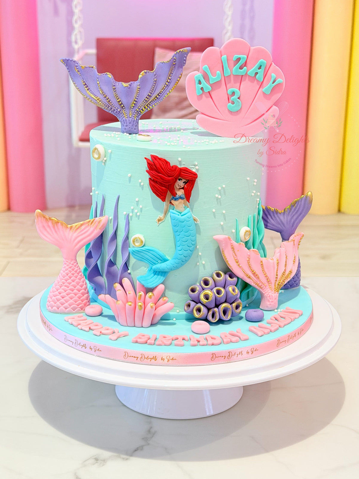 Ariel Mermaid Tails Cake with aqua frosting, colourful mermaid tails and seashell decorations in Dubai