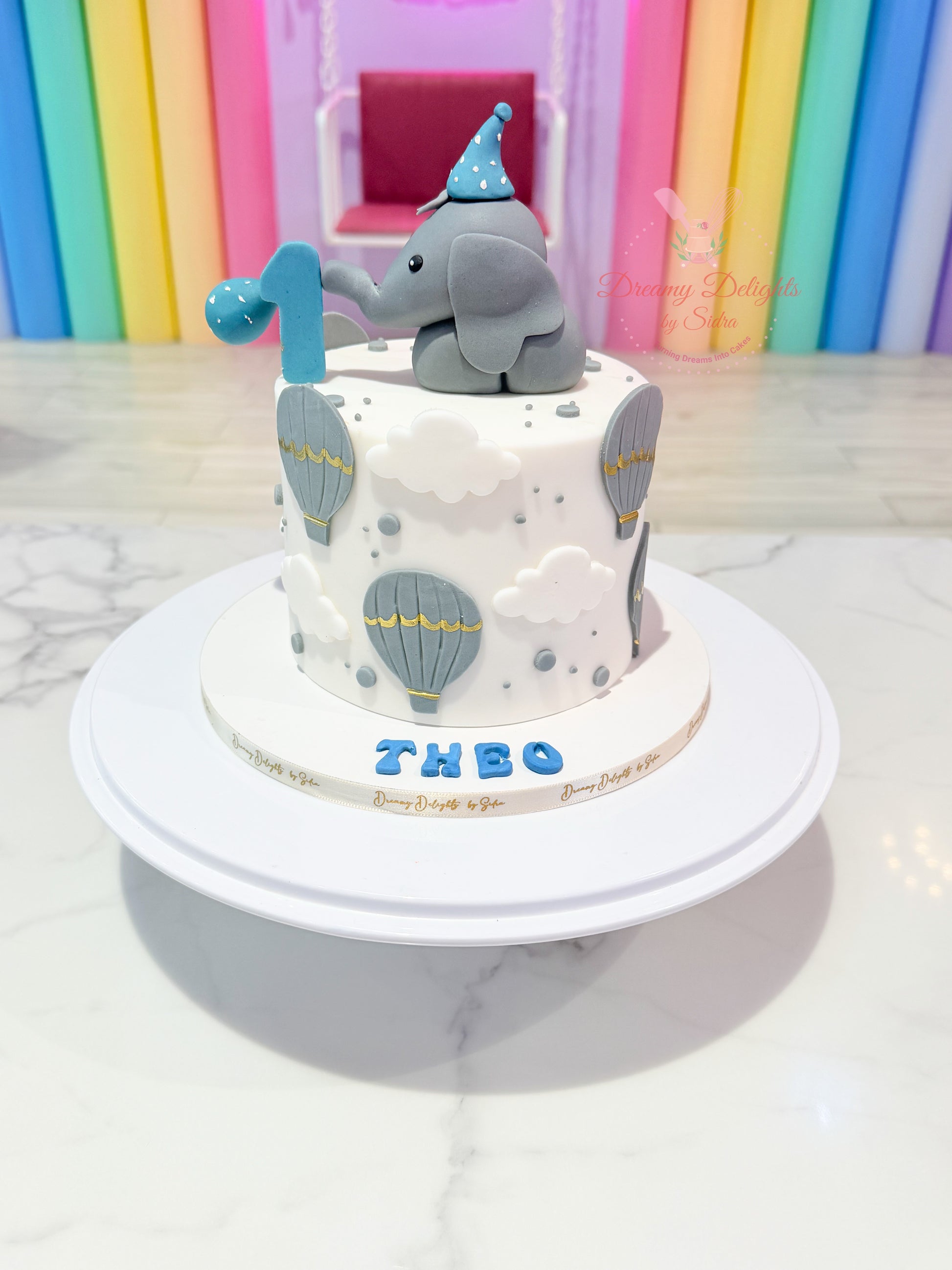 baby elephant first birthday cake Dubai with balloon theme and number one topper
