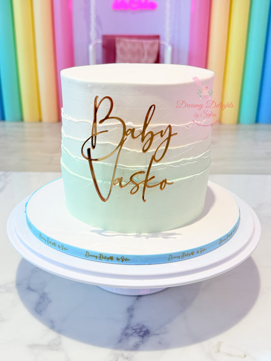 Elegant baby shower cake Dubai with personalized acrylic name reveal badge by Dreamy Delights by Sidra