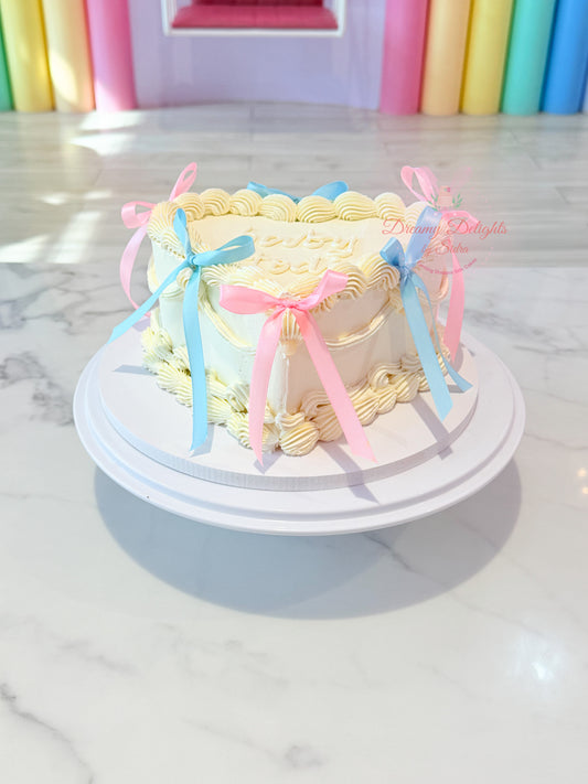 Pink and blue ribbon baby shower cake with vintage heart design and delicate piping in Dubai