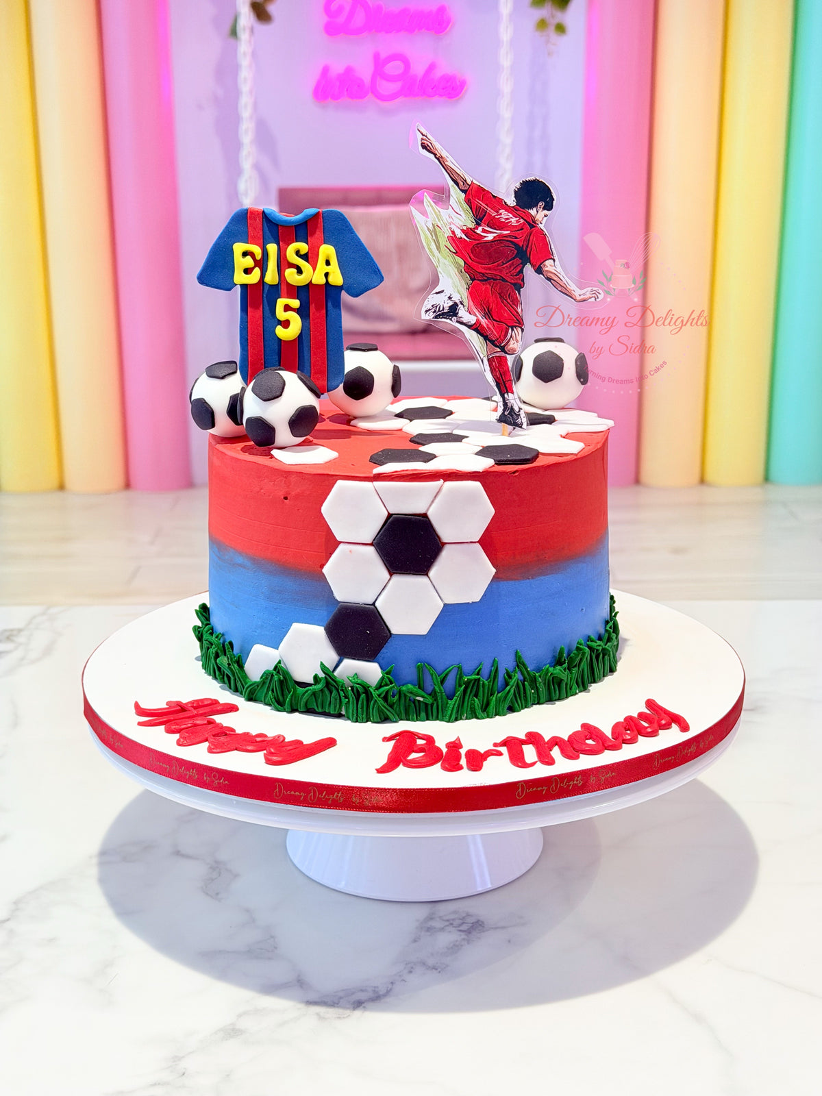 Barcelona football cake with red and blue frosting, football toppers and personalised jersey by Dreamy Delights by Sidra in Dubai.