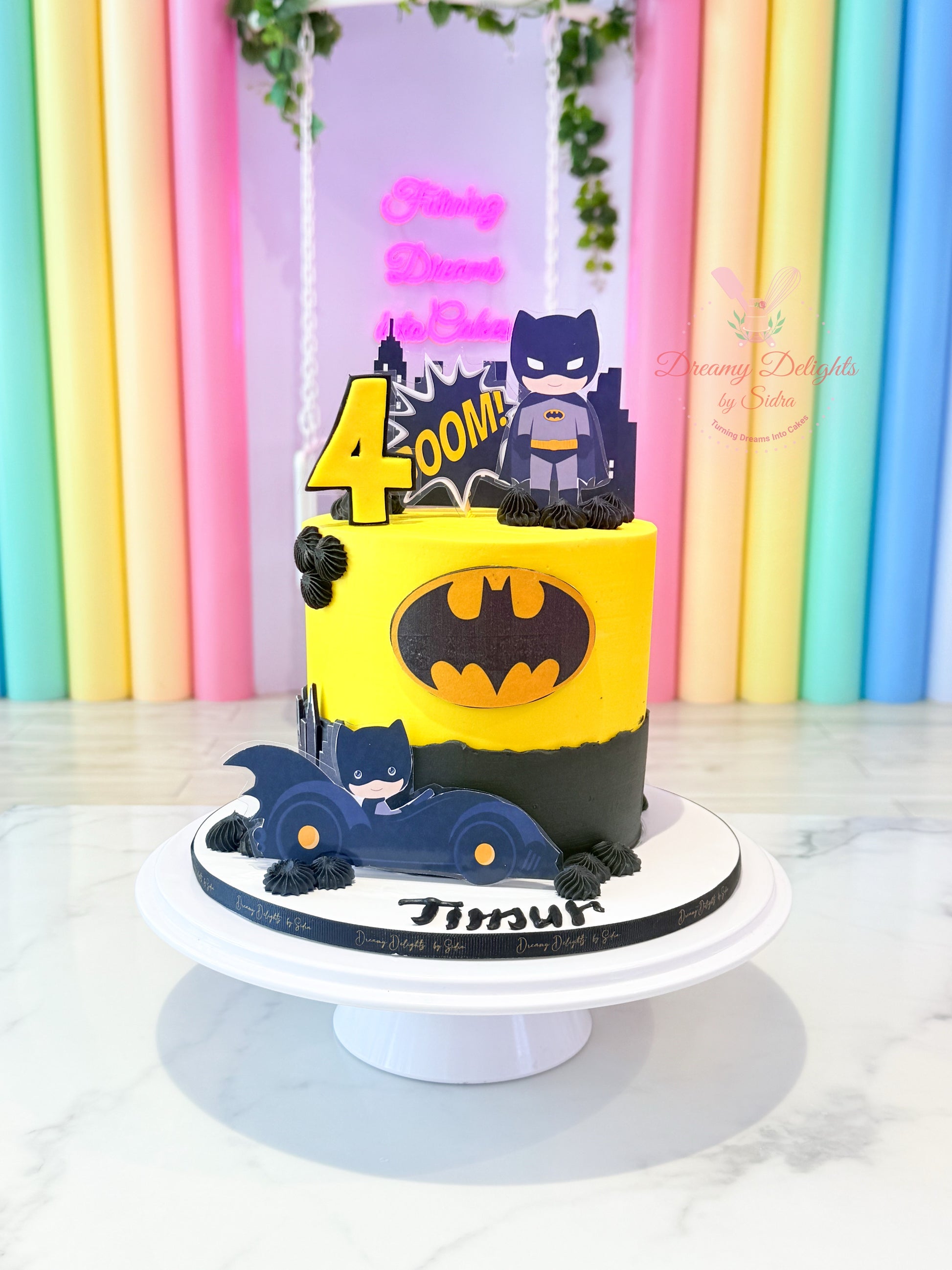 Batman-themed birthday cake with colorful background