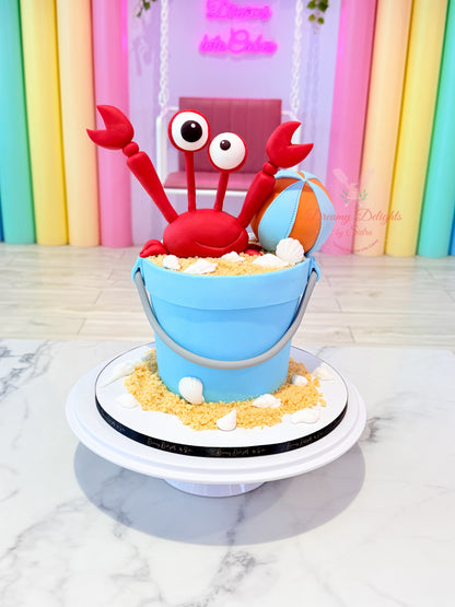 Beach Bucket Crab Cake with crab topper, seashells, and beach-themed decorations for boys in Dubai