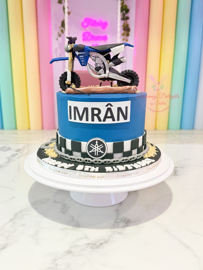 Motorcycle-themed birthday cake with 'IMRöN' on a colorful striped background