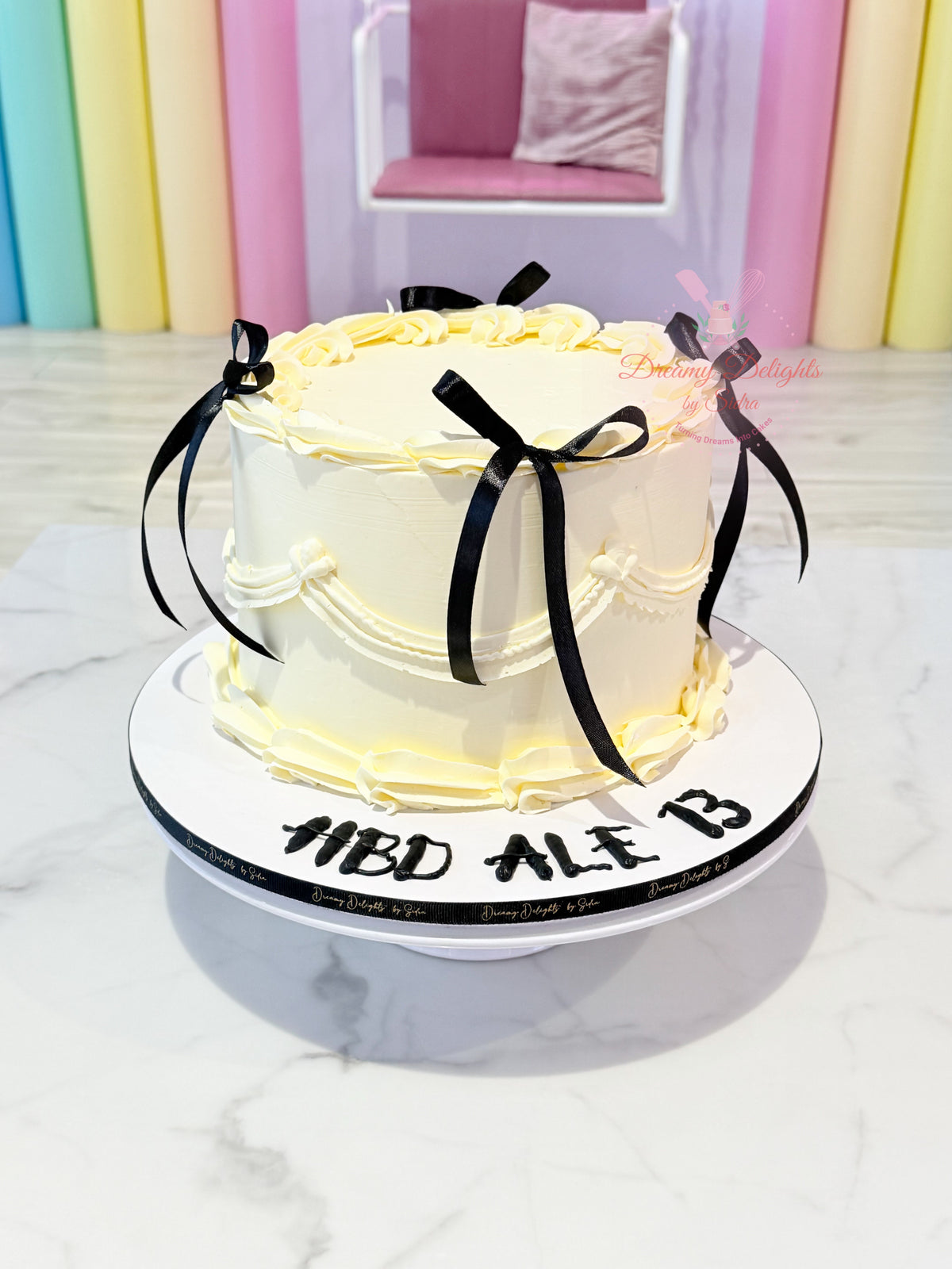 Ivory vintage cake for her with black satin bows and piped buttercream by Dreamy Delights by Sidra in Dubai