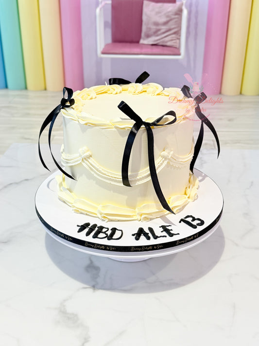 Ivory vintage cake for her with black satin bows and piped buttercream by Dreamy Delights by Sidra in Dubai