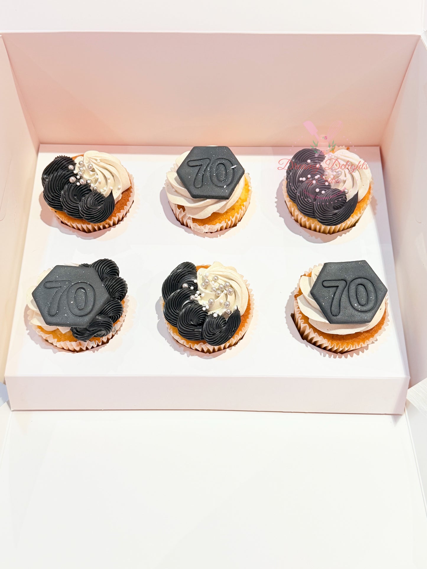 Elegant black and white celebration cupcakes with custom fondant toppers and buttercream swirls for birthdays and events in Dubai.