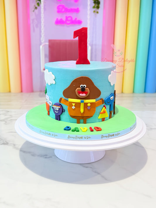 Duggee cake for boys Dubai with blue buttercream, colourful characters and a personalised age by Dreamy Delights by Sidra