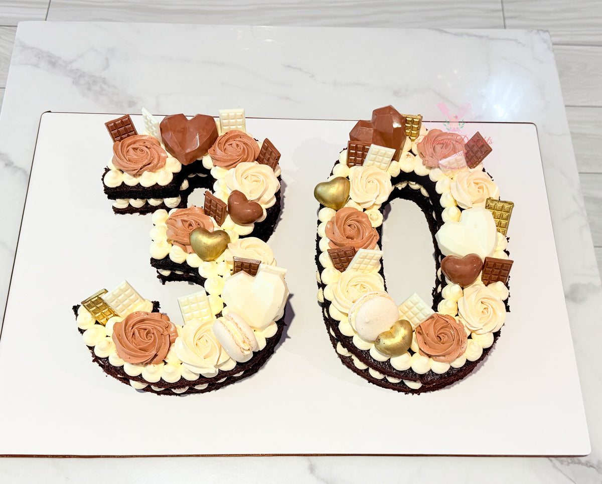 Chocolate age number cake for him featuring two carved numbers, chocolate hearts, chocolate pieces, and buttercream roses by Dreamy Delights by Sidra in Dubai