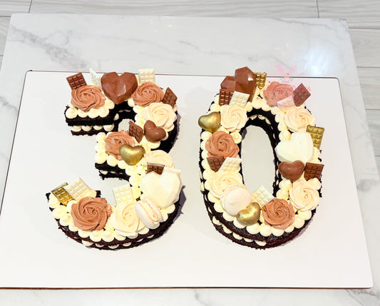 Chocolate age number cake for him featuring two carved numbers, chocolate hearts, chocolate pieces, and buttercream roses by Dreamy Delights by Sidra in Dubai