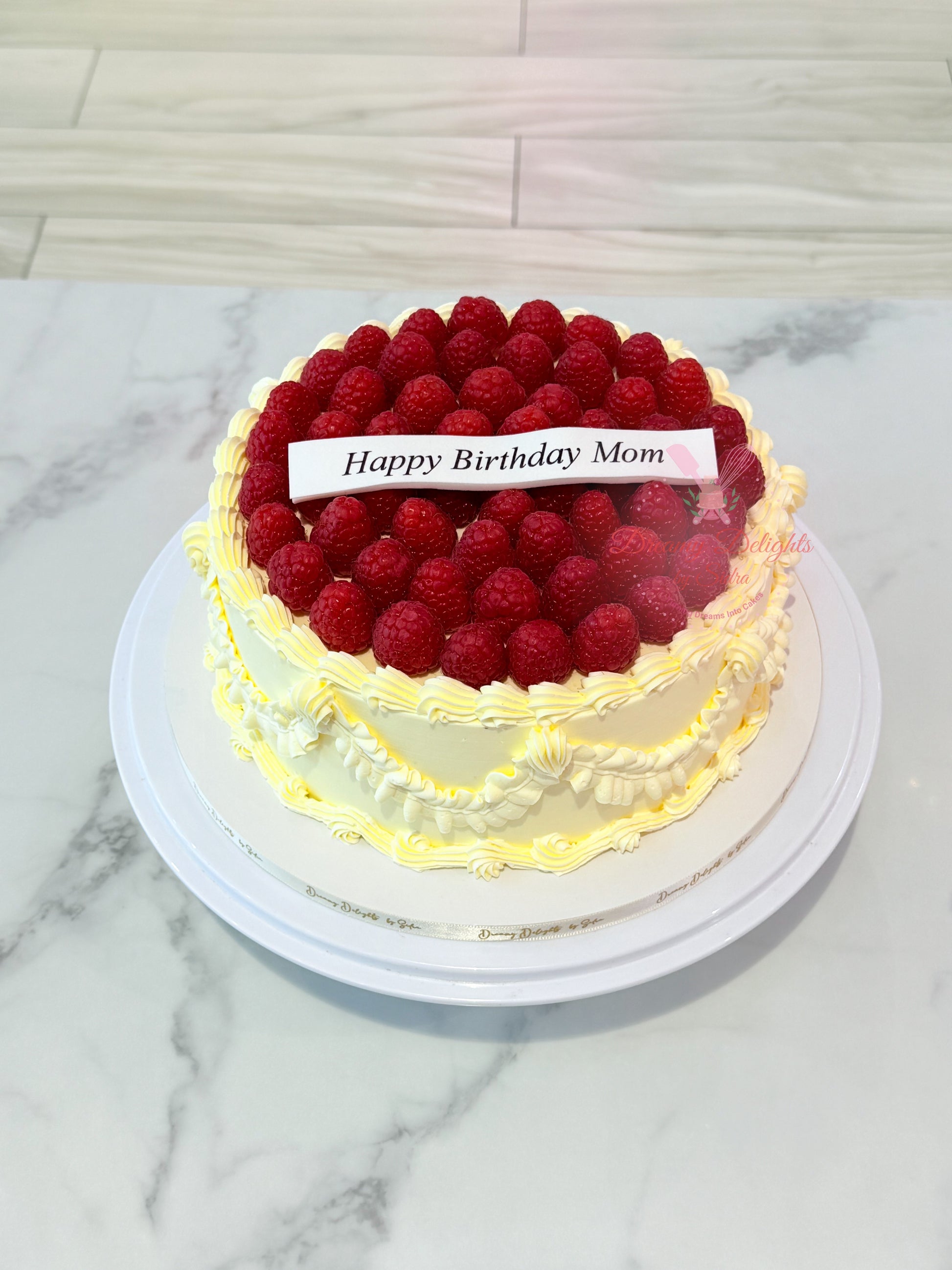 Classic raspberry fresh cream birthday cake with whole raspberry topping and cream piping in Dubai