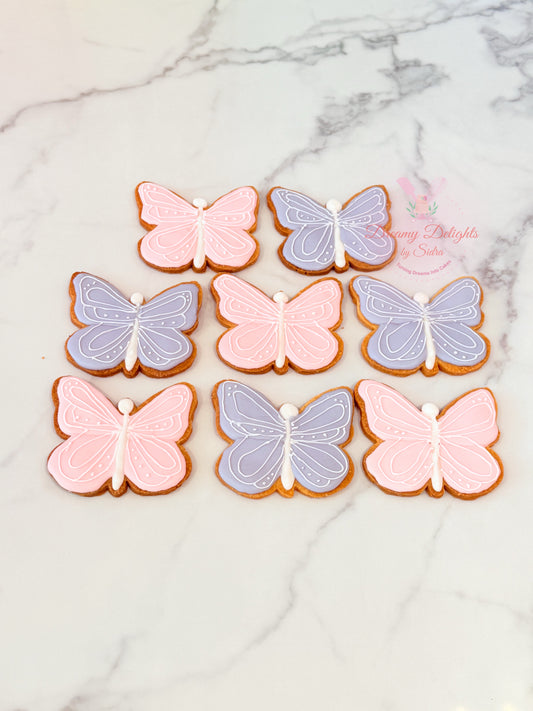 Butterfly cookies in pink and purple on a marble surface
