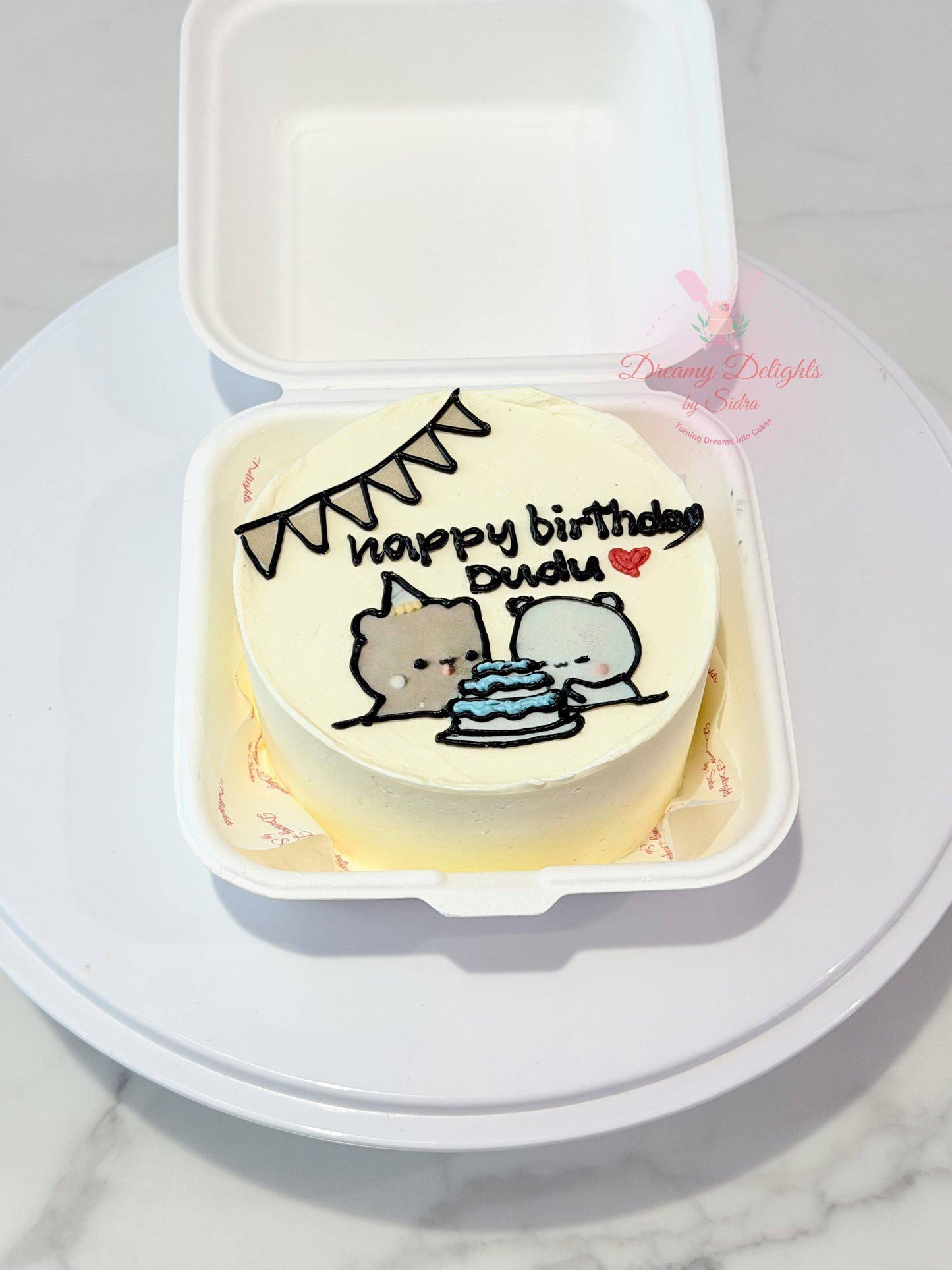 Cute cartoon birthday bento cake with hand-piped characters, birthday cake illustration, and personalized message in Dubai.
