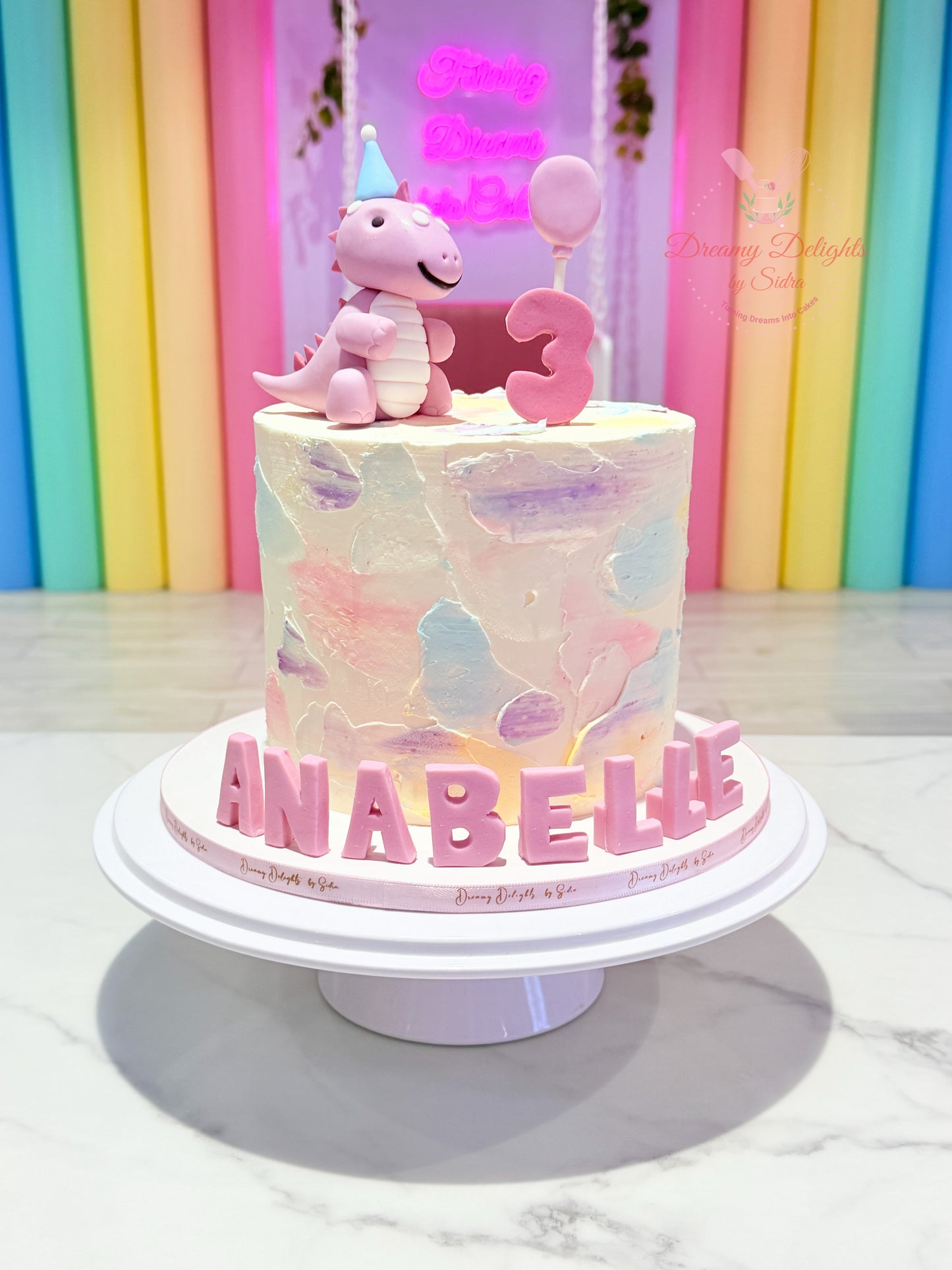 Cute Girl Dinosaur Cake with pastel dinosaur topper, customized kids birthday cake for girls in Dubai