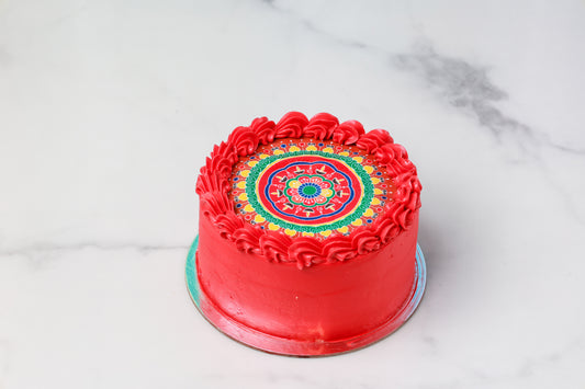 Red cake with colorful mandala design on a marble surface
