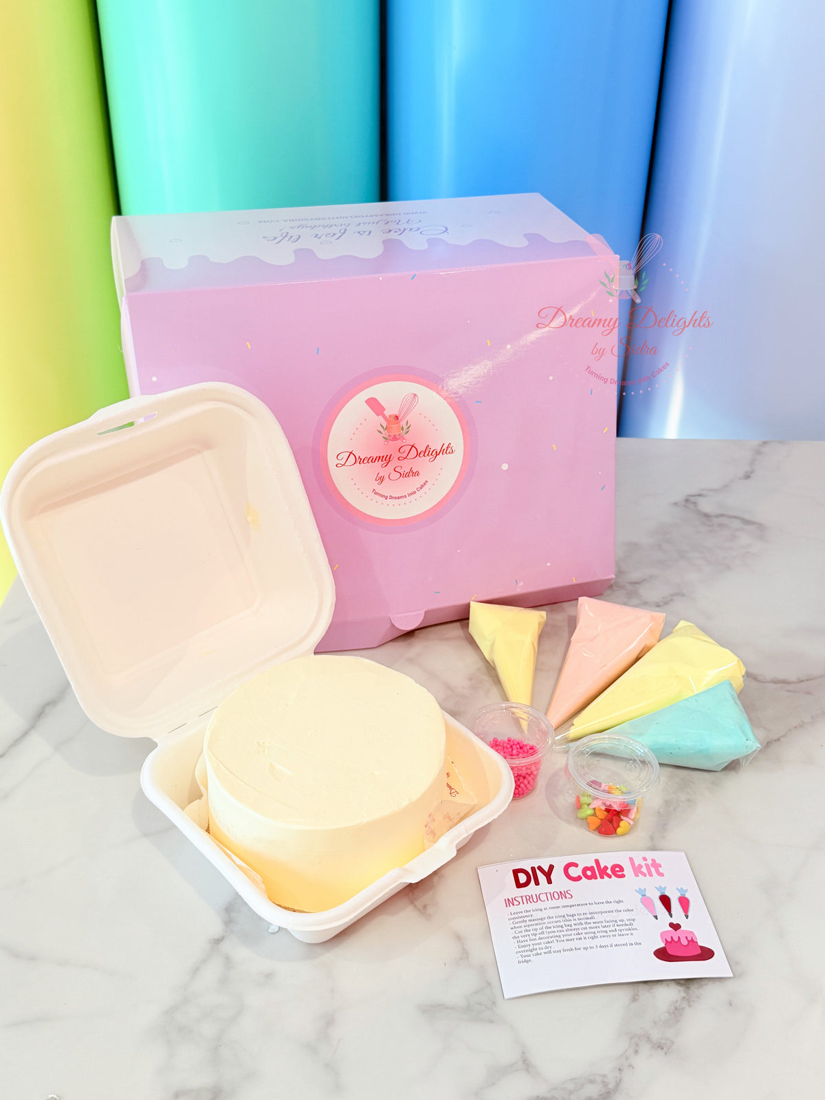 DIY cake decorating kit with cake, icing bags, sprinkles and decorations