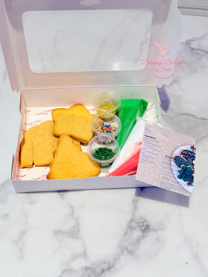 Baking kit with yellow star-shaped cookies, decorating supplies, and a recipe card on a marble surface.