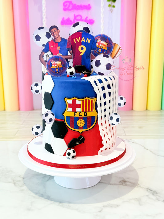 Cake decorated with soccer-themed elements and a player figure, featuring the FC Barcelona logo.